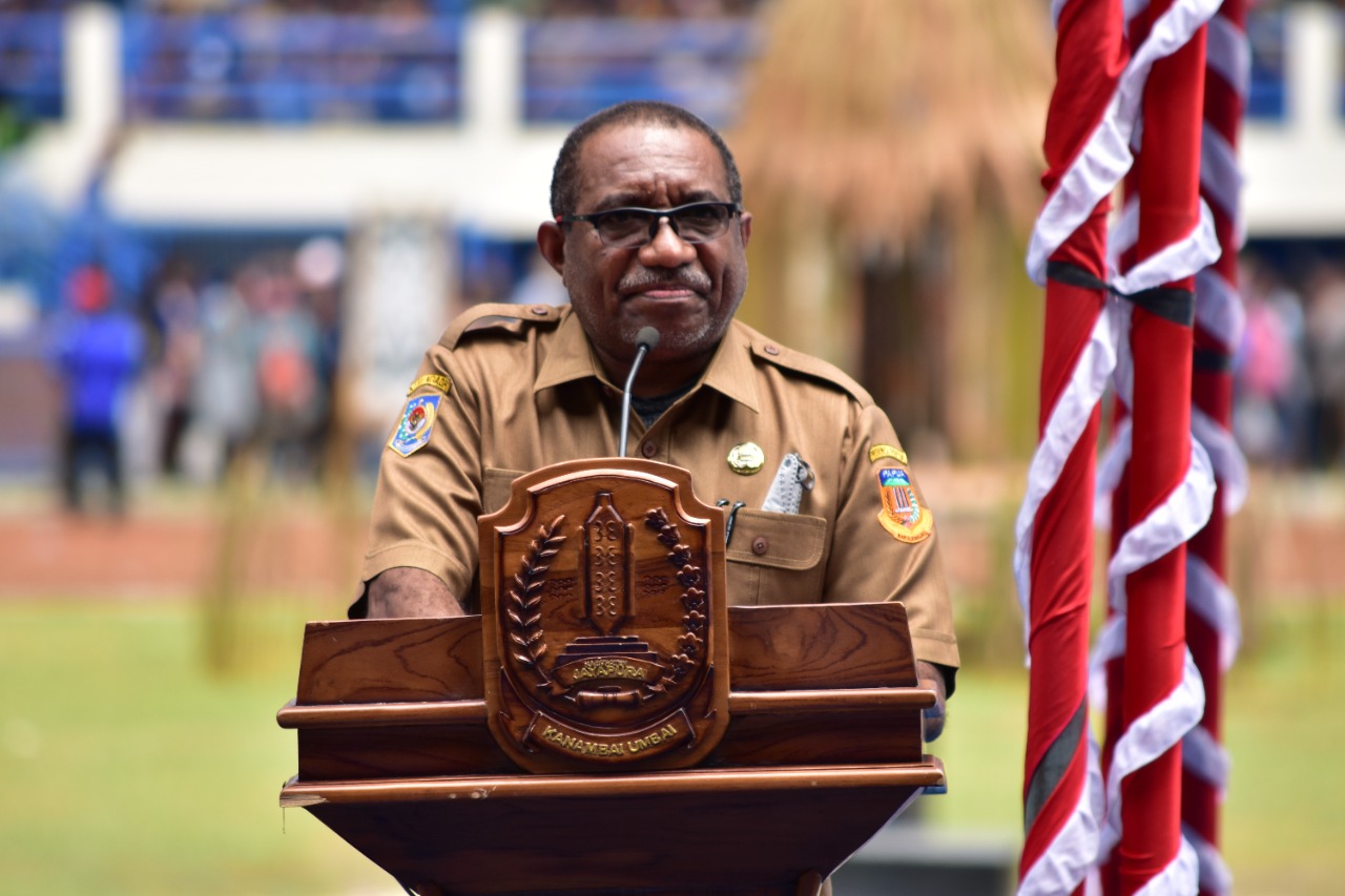 Asisten III bidang pemerintahan umum setda provinsi Papua, Y . Derek Hegemur saat membacakan sambutan Gubernur Papua, Lukas Enembe di Pembukaan KMAN VI, Stadion Barnabas Youwe, Sentani.