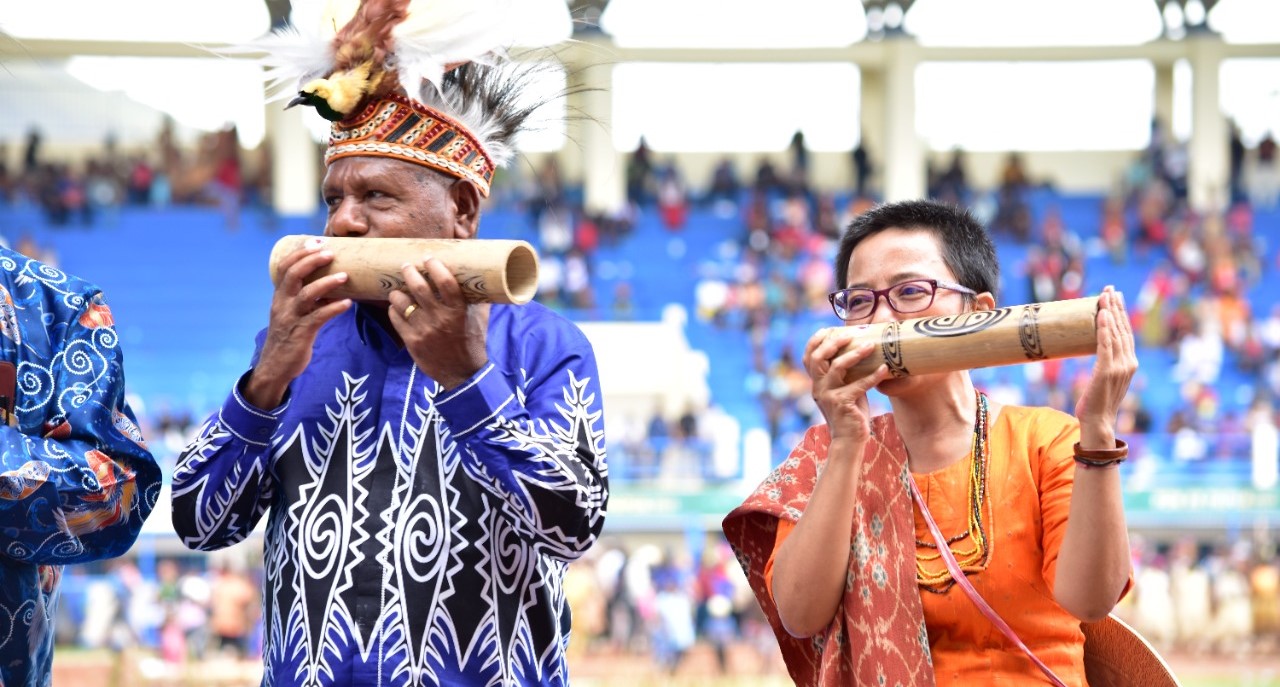 Sekjen AMAN, Rukha Simbolingi Bersama Ketua Panitia KMAN VI, Mathius Awoitauw,SE,M.Si meniup alat music Fu pada pembukaan KMAN VI